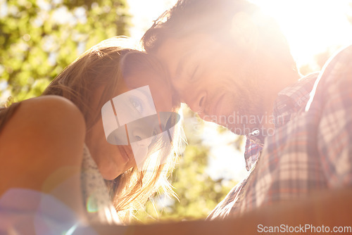 Image of Lens flare, couple or forehead touch on love date, valentines day or bonding hug in nature park, relax garden or low angle. Smile, happy man or embrace woman in trust, security or partnership support