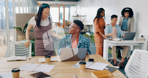 Image of Teamwork, laptop and business people fist bump in office for success celebration. Training, coaching and Asian woman teaching black man, support and advice while celebrating after solving problem.