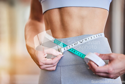 Image of Tape measure, stomach and woman at gym for weight loss, diet or exercise on blurred background. Fitness, measuring and girl on flat belly from training, workout or healthy lifestyle results on mockup