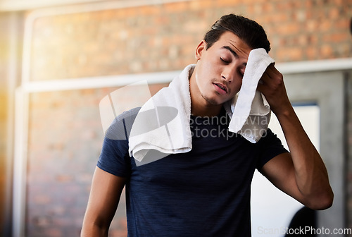 Image of Tired, sweat and man at gym for exercise, cardio or intense workout on brick wall background. Exhausted, athlete or male with towel stop to rest or recover from sport, performance or challenge