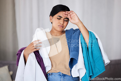 Image of Tired cleaner, Indian woman and laundry work in a house with cleaning and burnout. Maid, headache and stress of young person in a living room lounge feeling fatigue from housekeeper chaos in a house