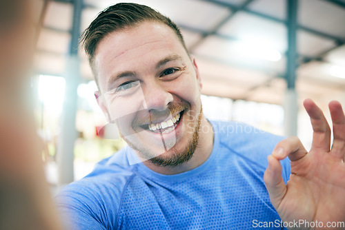 Image of Fitness, selfie and portrait of a man in a gym for exercise, cardio or sport training for wellness. Sports, health and face of a healthy male athlete with a ok gesture after a workout in a studio.