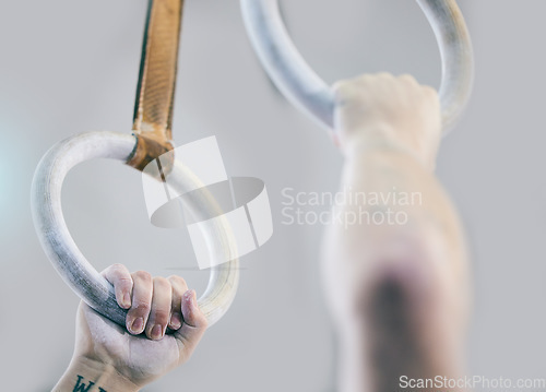 Image of Gymnast rings, fitness and hands zoom in a health, wellness and training center. Hand powder zoom, athlete and action performance of a man doing sports, gymnastics and competition with strength