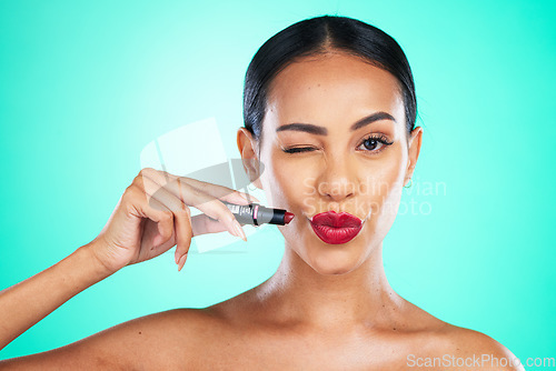 Image of Red lipstick, woman and wink of a beauty model with cosmetics product isolated. Studio, cosmetic and skincare of a young person with skin glow from dermatology with blue background and mockup