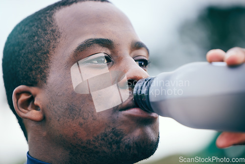 Image of Fitness, break and face of black man drinking water to hydrate after running, exercise and workout. Health, sports and African athlete with a bottle drink after training, sports and cardio in Germany