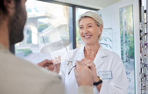 Image of Glasses, retail shop and vision of a senior eye doctor holding a frame to help customer shopping. Happy optometrist, store help and service of an elderly eyes expert with eyeglasses check promo
