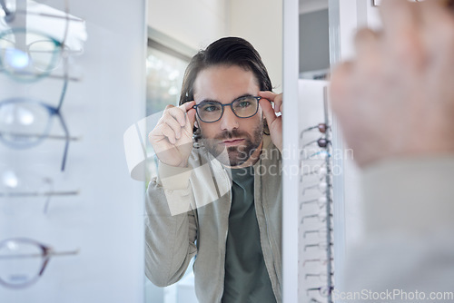 Image of Optometry, glasses choice and man check mirror for vision, eye care and customer experience in store with lens frame. Young client or person eyes healthcare, retail and shop test for optical wellness