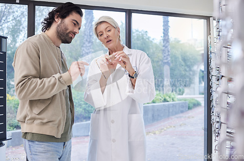 Image of Doctor, optician help man or glasses for clear vision, friendly services or conversation. Optical store, woman talking to male customer or shopping for eye care, discussion or new prescription lenses