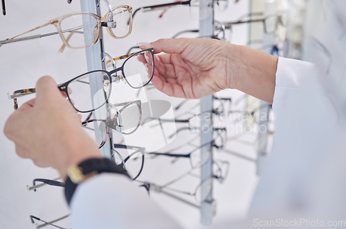 Image of Working, decision and hands of an optometrist with glasses, eyewear and frame for vision in a shop. Healthcare, retail and optician with a choice of eyeglasses for visual service and optics in store