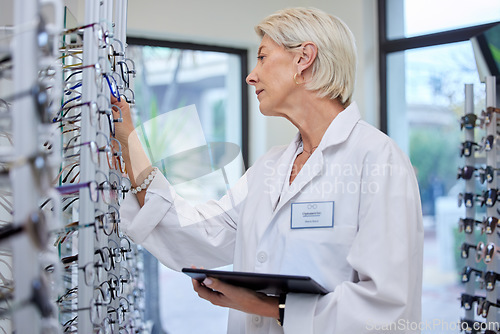 Image of Optometrist, glasses and professional in a store, retail or optician looking at specs or prescription lenses. Vision, eyesight and mature woman choosing eyewear, frames and spectacles at optic shop