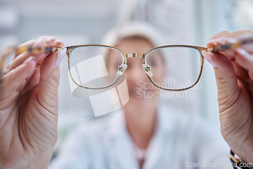 Image of Glasses, vision and optometrist doctor hands for eye wellness and health test in a shop or hospital. Healthcare, consulting and medical employee holding a frame with tested lens for customer