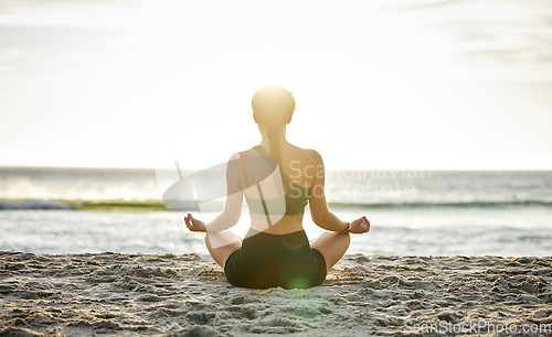 Image of Woman, yoga and meditation on the beach sunset for spiritual wellness, zen or workout in the outdoors. Female yogi relaxing and meditating for calm, peaceful mind or awareness by the ocean coast