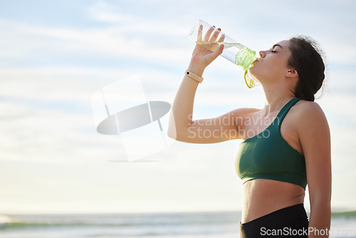 Image of Drinking water, fitness and woman on beach for running, exercise or outdoor workout nutrition, health and wellness. Liquid bottle for diet, goals and tired sports runner, athlete or person by sea
