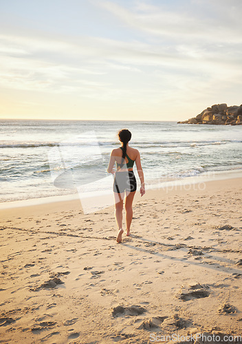 Image of Woman, beach and walking on sand for travel, vacation or holiday in nature for summer. Fitness person at ocean for sea or water view for peace, relax and calm time for freedom and mental health