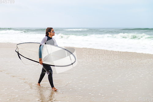 Image of Young female surfer wearing wetsuit