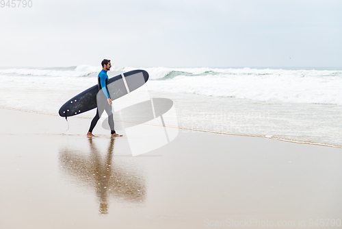 Image of Young male surfer wearing wetsuit