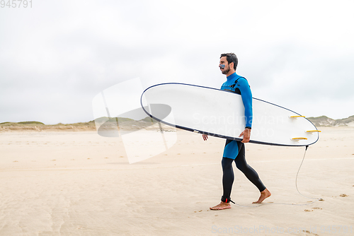 Image of Young male surfer wearing wetsuit