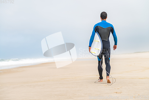 Image of Young male surfer wearing wetsuit