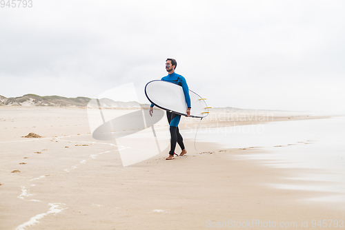 Image of Young male surfer wearing wetsuit