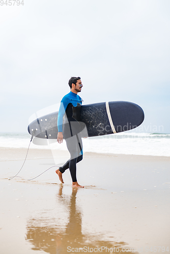 Image of Young male surfer wearing wetsuit