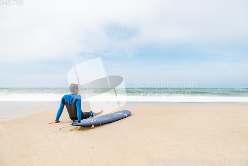 Image of Young male surfer wearing wetsuit