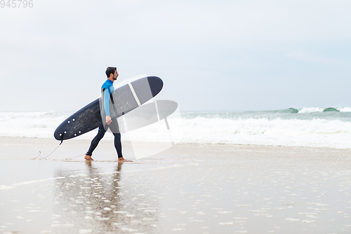 Image of Young male surfer wearing wetsuit
