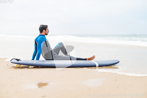 Image of Young male surfer wearing wetsuit