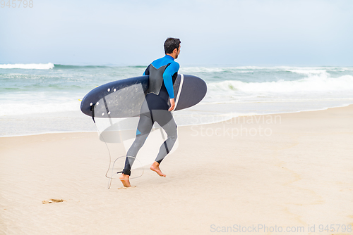 Image of Young male surfer wearing wetsuit