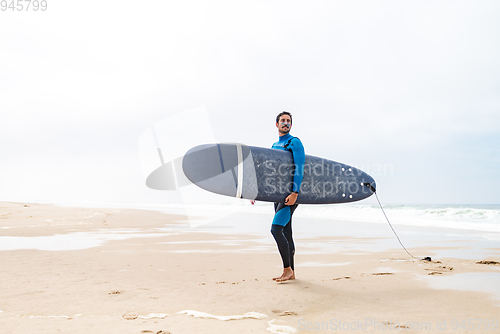 Image of Young male surfer wearing wetsuit