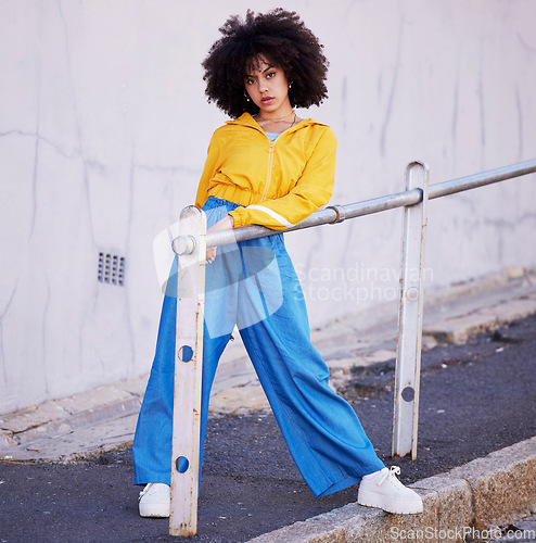 Image of Black woman, portrait and urban fashion in the city for stylish or colorful clothing with afro hair style. African American female fashionable model posing on pavement with funky clothes in a town