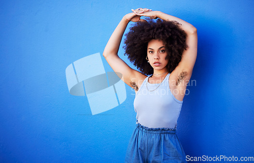 Image of Body positivity, empowerment and portrait of a woman with hair isolated on a blue background. Beauty, natural and African girl showing armpit with confidence, feminism and attractive on a backdrop