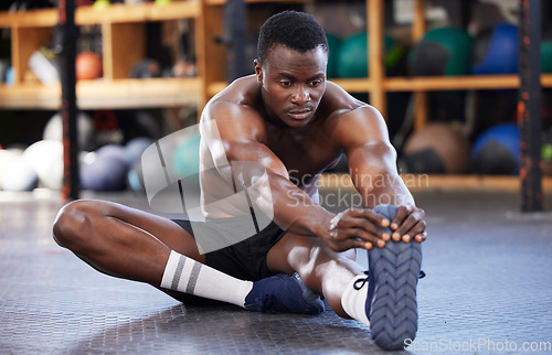 Image of Stretching. fitness and health with black man in gym for sports, workout and performance. Wellness, exercise and training with athlete and warm up legs on floor for cardio, endurance and energy