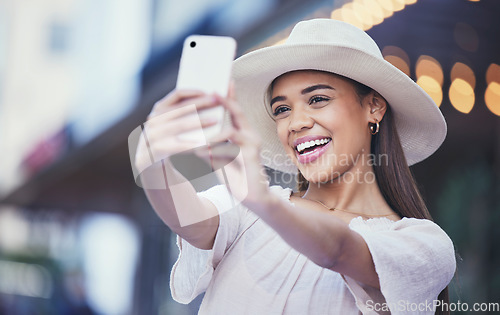 Image of Woman, vlogger and social media with smile in the city for selfie, travel or profile picture and memories. Happy female influencer smiling for vlog, traveling or online 5G connection in an urban town