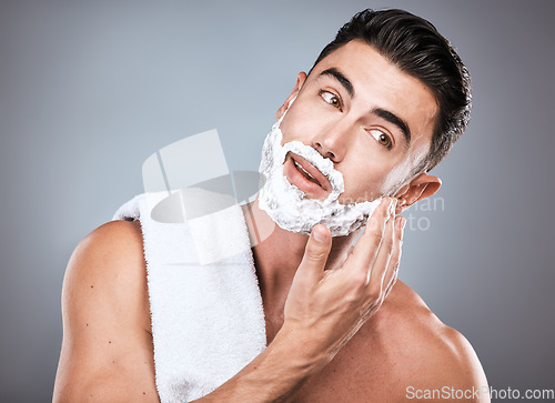 Image of Face, shave foam and grooming with a man model in studio on a gray background for hair removal. Beard, hand and skincare with a handsome young male in the bathroom for shaving in the morning