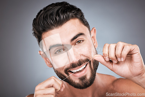 Image of Dental floss, teeth and portrait of man in studio for beauty, healthy body and hygiene on background. Male model, tooth flossing and cleaning mouth for facial smile, fresh breath and happy cosmetics