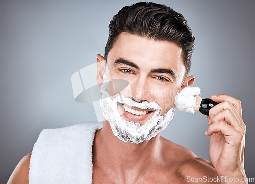 Image of Face, shaving cream and man with brush in studio isolated on gray background for hair removal. Haircare portrait, epilation and happy male model with facial product, foam or gel to shave for wellness