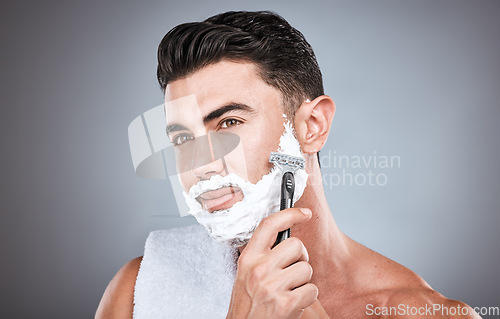 Image of Face, shaving cream and man with razor in studio isolated on a gray background. Skincare, cleaning and thinking male model with facial product, foam or gel to shave for wellness, health and hygiene.