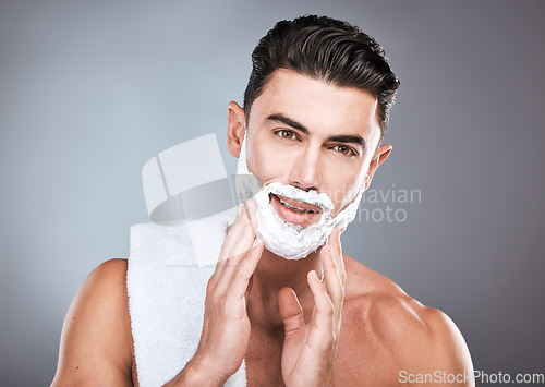 Image of Face, shaving cream and grooming with a man model in studio on a gray background for hair removal. Shave, hands and skincare with a handsome young male in the bathroom for a shave in the morning