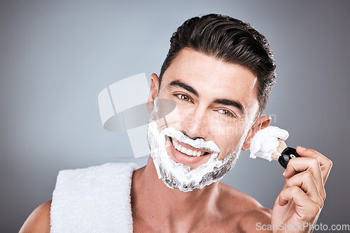 Image of Brush, shaving cream and face of man in studio isolated on a gray background for hair removal. Beard care portrait, skincare and male model with facial product, foam or gel to shave for wellness.