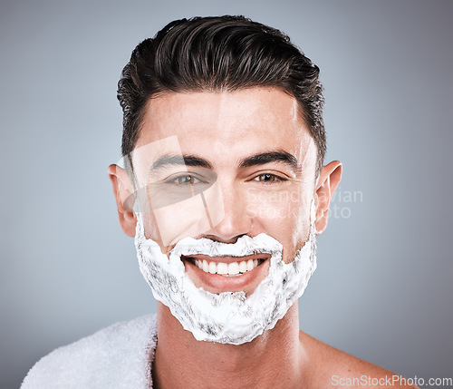 Image of Grooming, shaving and portrait of a man with cream on face isolated on a grey studio background. Happy, hygiene and headshot of a person with a facial product for beard hair removal on a backdrop