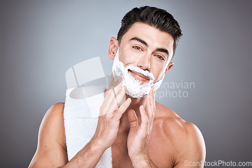 Image of Portrait, shave cream and grooming with a man model in studio on a gray background for hair removal. Face, hand and skincare with a handsome young male in the bathroom for shaving in the morning