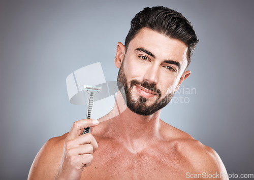 Image of Face, portrait and man with razor in studio isolated on a gray background for shaving. Skincare, cleaning and male model with facial product to shave for wellness, health hygiene and hair removal.