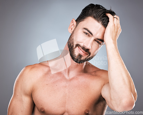 Image of Beauty, smile and portrait of man with hand in hair, sexy beard maintenance and healthy skincare. Fitness, health and spa facial care, male model with muscle in studio isolated on grey background.