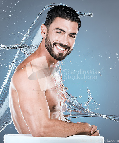 Image of Water, splash and man in shower man, portrait for hygiene, .beauty and skincare isolated on blue background. Smile, face and cleaning body with muscle, sustainability and happy with natural cosmetics