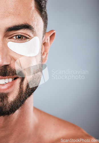 Image of Half, face and man with eye patch in studio isolated on a gray background for wellness. Portrait, skincare or male model with cosmetics, facial treatment or product for eyes, wellness or healthy skin