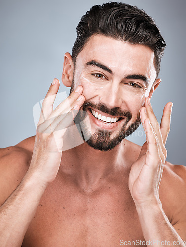 Image of Portrait, skincare and man with cream in studio isolated on a gray background for facial wellness. Face, dermatology cosmetics or happy male model with lotion, creme or moisturizer product for health