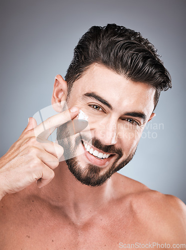 Image of Skincare, clean and portrait of a man with face cream isolated on a grey studio background. Beauty, grooming and model applying facial sunscreen for body dermatology, hygiene and sun protection