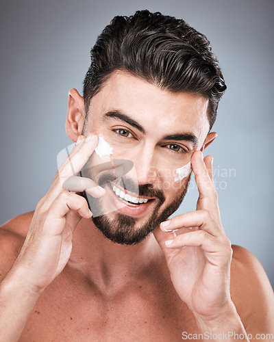 Image of Skincare, happy and portrait of a man with face cream isolated on a grey studio background. Beauty, grooming and model with facial sunscreen for body dermatology, hygiene and protection on a backdrop