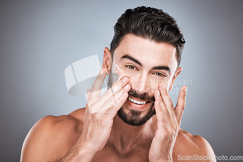 Image of Face portrait, skincare and man with cream in studio isolated on a gray background for facial wellness. Cosmetics, dermatology or happy male model with lotion, creme or moisturizer product for health