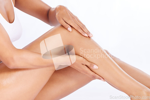 Image of Skincare, legs and woman in studio sitting with hand on leg for hair removal and moisturiser product placement. Smooth shave, skin and beauty, body care with mockup, girl isolated on white background
